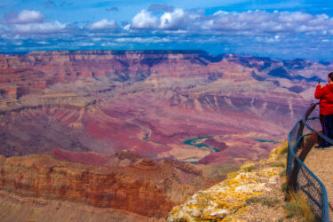 Three people admiring the vista at a Grand Canyon lookout point