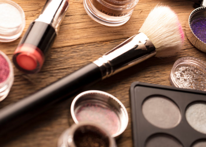 Desk full of open makeup containers