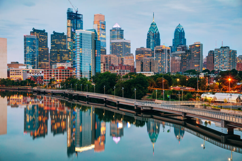 Philadelphia skyline next to water at dusk