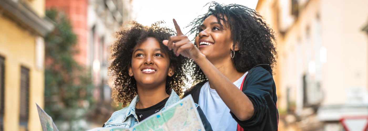 Mother and daughter navigate city using paper map