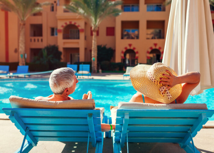 Senior couple relaxing by the pool at an all-inclusive resort