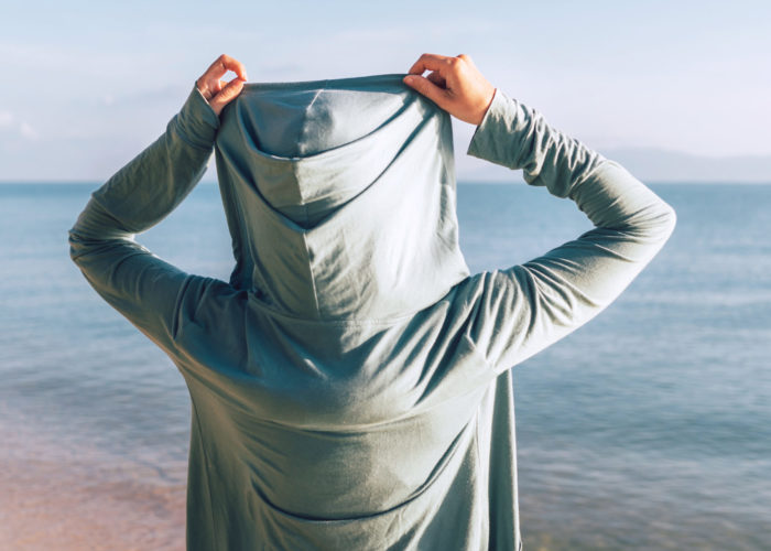 Person wearing a hoodie at the beach