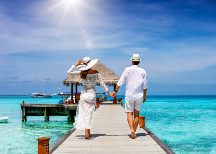 Couple walking towards an overwater bungalow