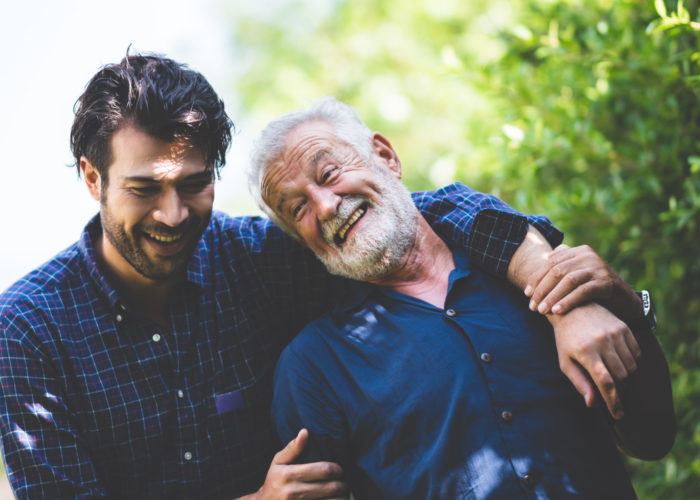 Father and son walking together down a green outdoor path