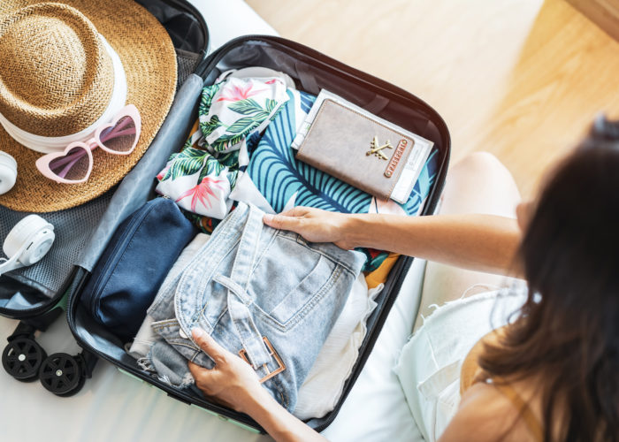 Overhead view of woman packing a suitcase