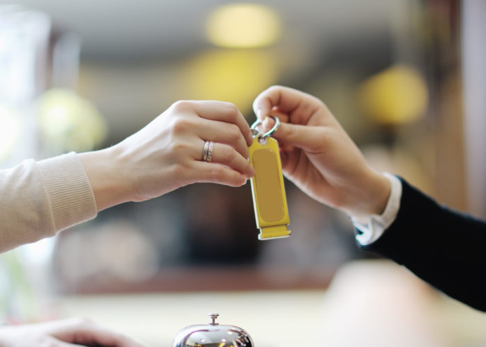 Close up of hotel concierge handing a room key off to a guest