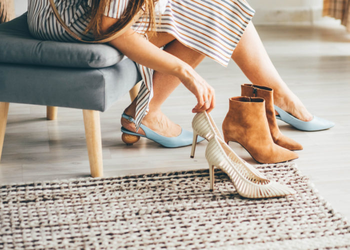 Woman trying on multiple pairs of heeled shoes