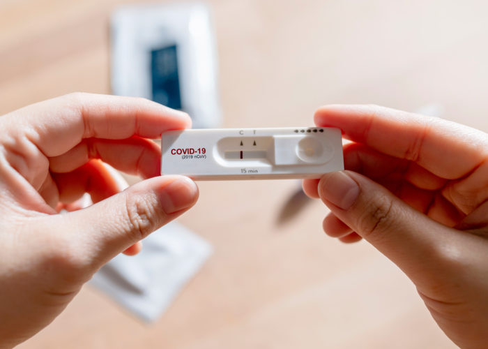 Close up of person's hands holding a negative at-home antigen COVID test