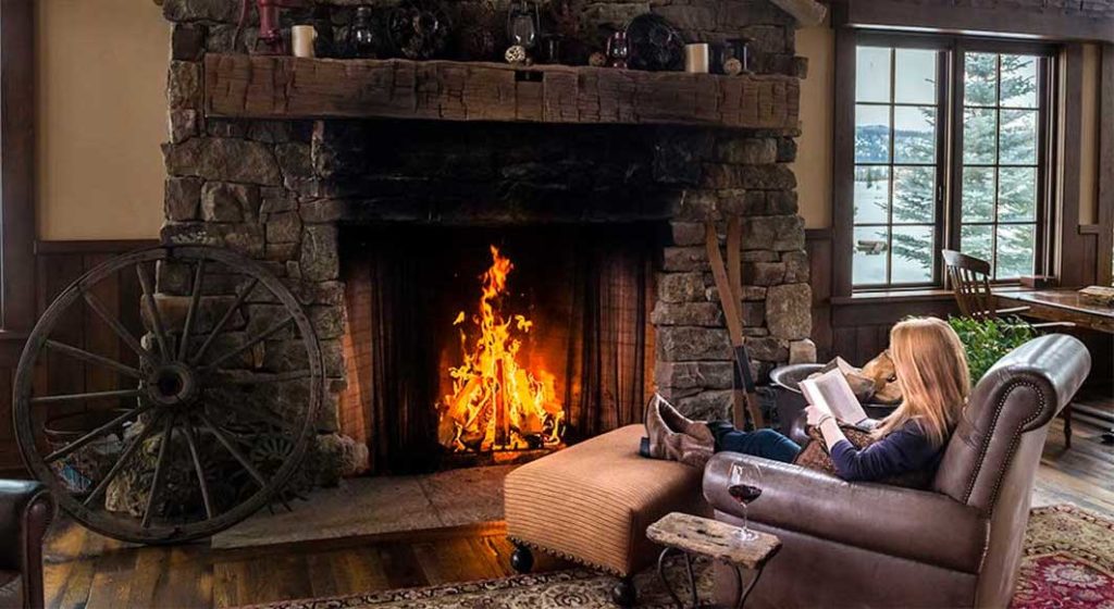 Guest enjoying the fire in a lounge area at Vista Verde Guest Ranch