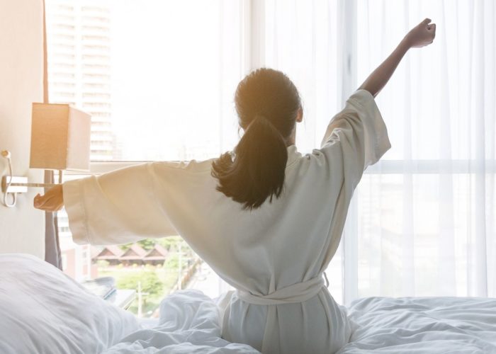 woman waking up in hotel room