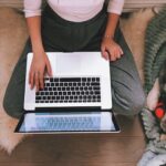 woman sitting at window looking at laptop